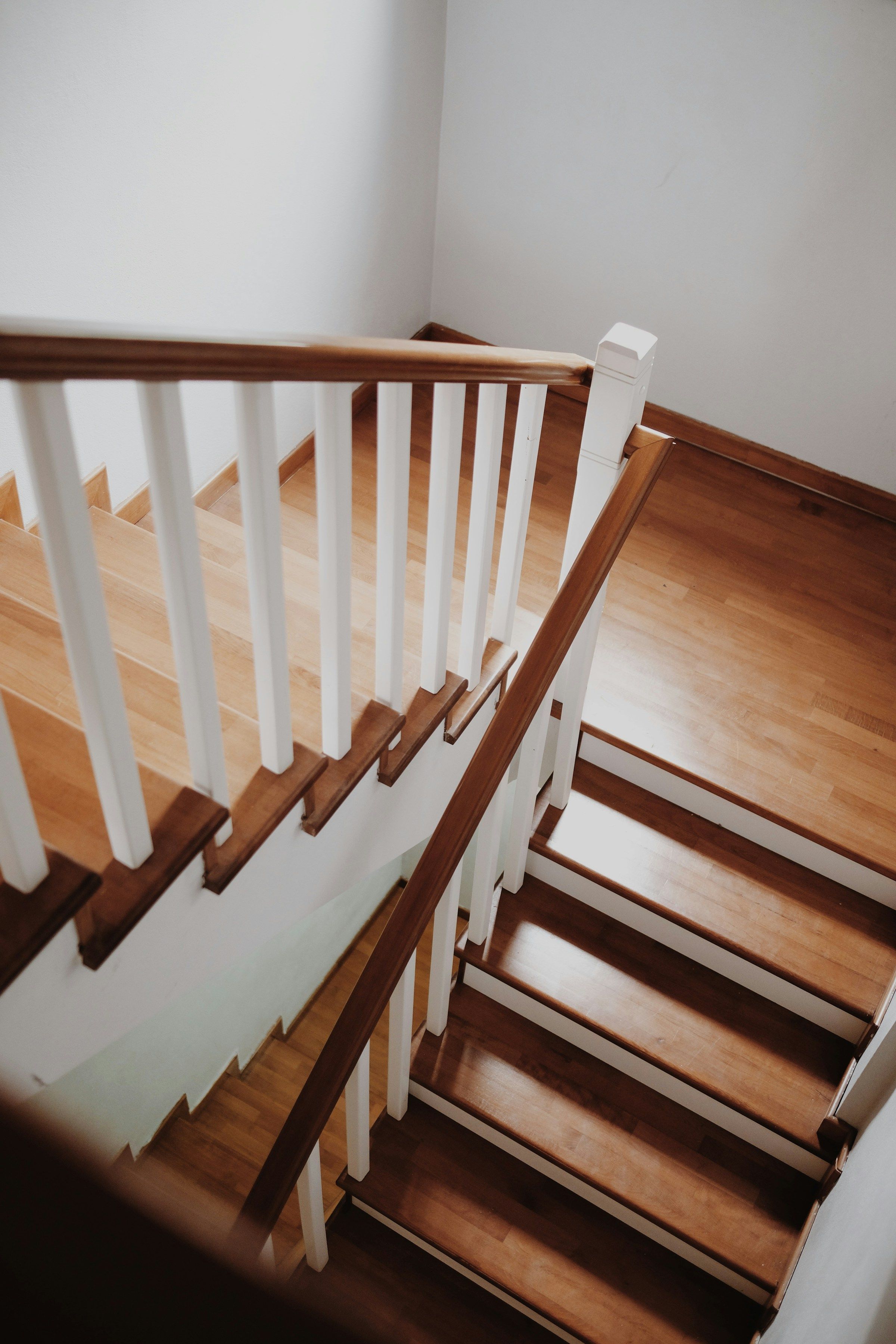 Holztreppe im Wohnhaus mit weißen Geländerstäben und Holzhandlauf